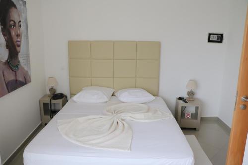 a white bed with a blanket on it in a room at Vista Mar in Tarrafal