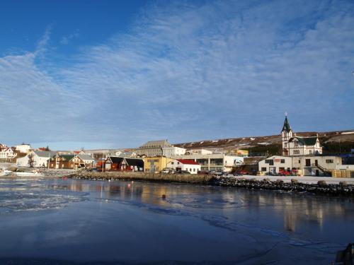 a town next to a body of water with buildings at Askja Apartment in Húsavík