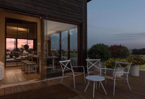a patio with chairs and tables on a deck at Neot Golf, Ziv's Place in Caesarea