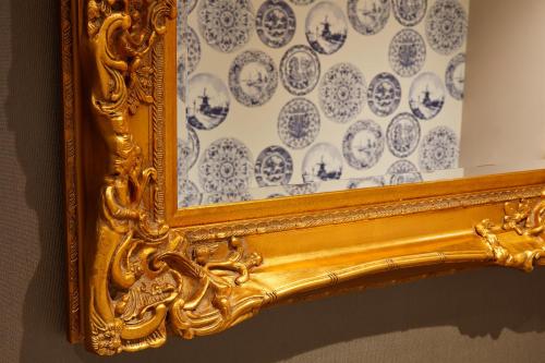 a gold picture frame with a blue and white patterned wall at Oddfellows On The Park in Cheadle