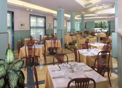 jadalnia ze stołami, krzesłami i stolarką w obiekcie Hotel Diana w mieście Bellaria-Igea Marina