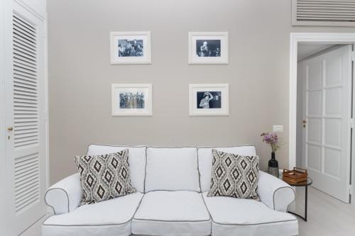a white couch in a living room with pictures on the wall at Casa Di Capri in Capri