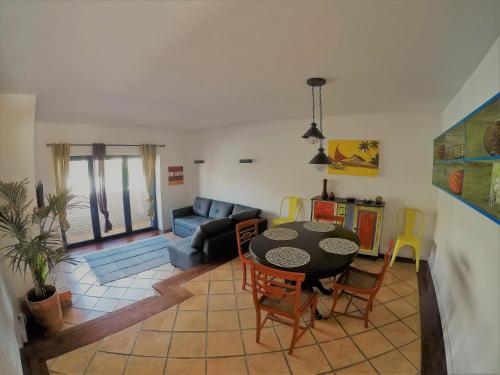 uma sala de estar com uma mesa e um sofá em Beach House na Madalena