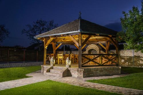 a wooden gazebo in a yard at night at Amfora in Palić