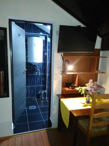 a bathroom with a shower with a table and a dining room at Rooms Hazler in Slunj