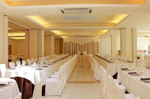 a large banquet hall with white tables and white chairs at Hotel Villa Verdefiore in Appignano