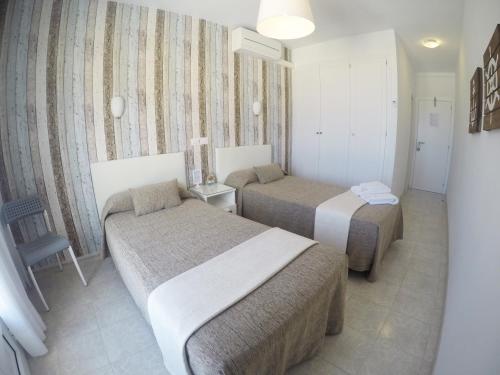 ein Hotelzimmer mit 2 Betten in einem Zimmer in der Unterkunft Hostal del Mar in Tossa de Mar
