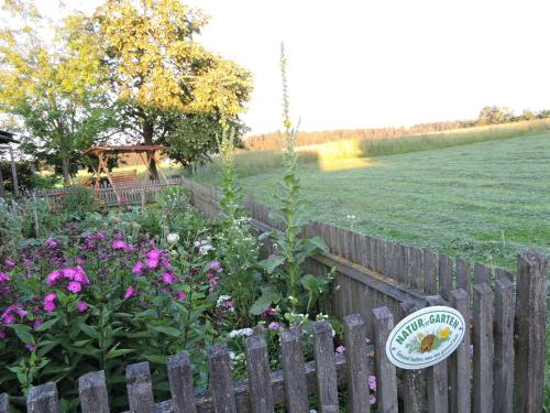 a wooden fence with a garden with flowers at Ferienwohnung Pichler in Traunstein
