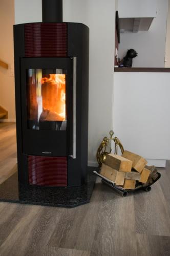 a fireplace in a living room with a pile of wood at Chalet Taube in Bad Gastein