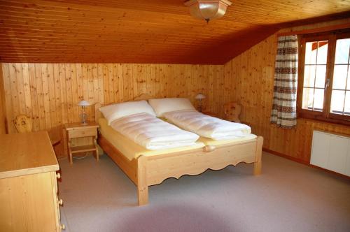 a bedroom with a bed in a wooden room at Ferienwohnung Uf dr Liwwi in Grindelwald