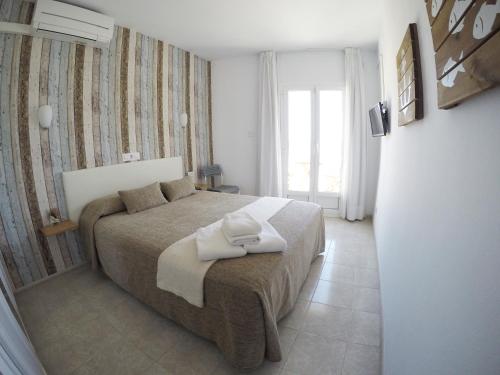 a bedroom with a bed with two towels on it at Hostal del Mar in Tossa de Mar