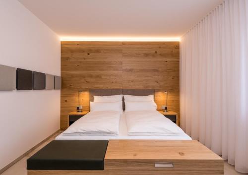 a bedroom with a large bed with a wooden headboard at 24/7 Zimmer Asten in Asten