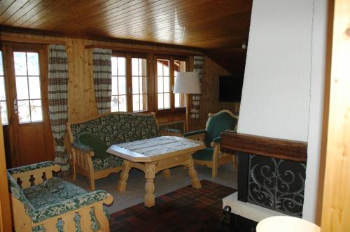 a living room with a couch and a table and chairs at Ferienwohnung Uf dr Liwwi in Grindelwald