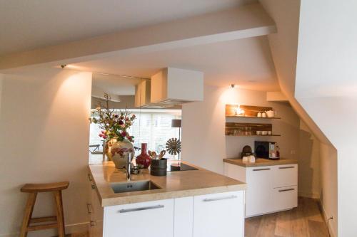 a kitchen with white cabinets and a sink at Short stay Midden Drenthe in Beilen