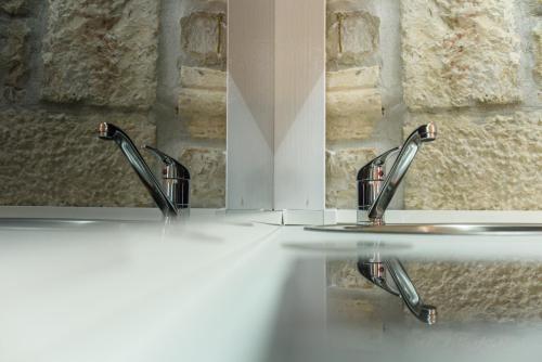 two sinks in a bathroom with two mirrors at Studio Apartman REA in Trogir