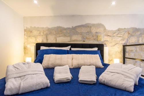 a bedroom with a blue bed with towels on it at Studio Apartman REA in Trogir