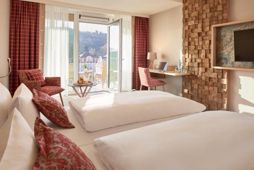a hotel room with two beds and a balcony at Dorint Resort & Spa Bad Brückenau in Staatsbad Brückenau