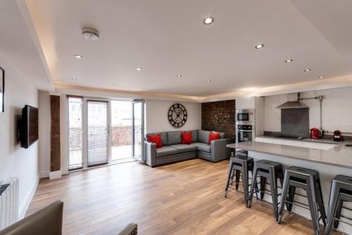 a living room with a couch and a kitchen at The Picture House Apartments in Liverpool