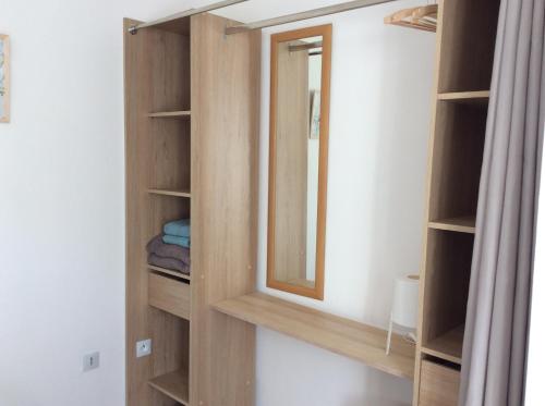 a bathroom with a wooden closet with a mirror at Number 7 Gouarec in Gouarec