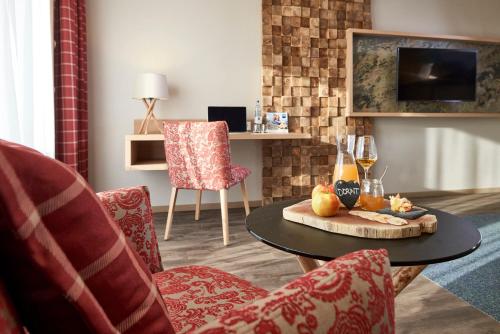 a living room with a table and chairs at Dorint Resort & Spa Bad Brückenau in Staatsbad Brückenau