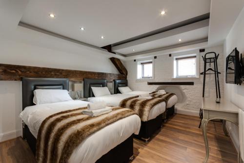 a group of four beds in a room with a fireplace at The Picture House Apartments in Liverpool
