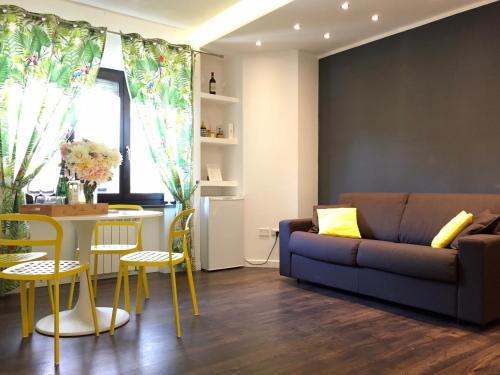 - un salon avec un canapé, une table et des chaises dans l'établissement Apartment Pompei Wellness, à Pompéi