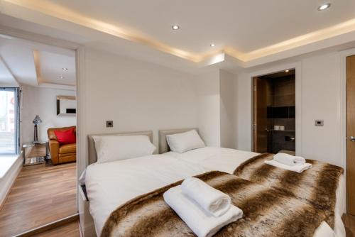 a bedroom with a large white bed with two towels on it at The Picture House Apartments in Liverpool