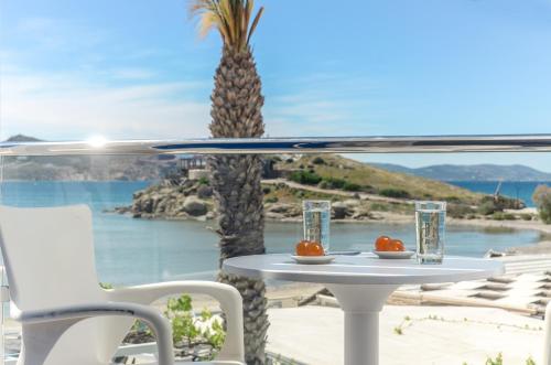 a table and chairs with a view of the ocean at Saint George Hotel in Naxos Chora