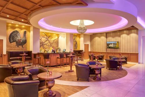 a restaurant with tables and chairs and a bar at Dorint Resort & Spa Bad Brückenau in Staatsbad Brückenau