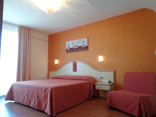 a hotel room with a bed and a chair at Hotel La Rondine in Sirmione