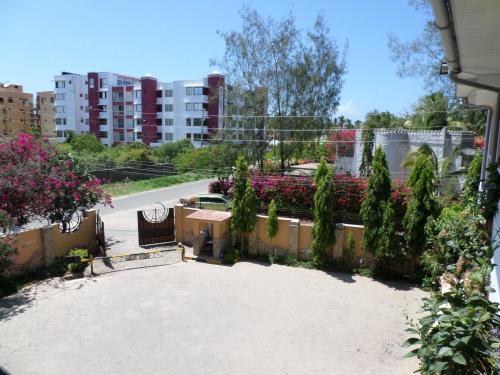 a view of a garden with flowers and trees at Pinebreeze Holiday Resort in Nyali
