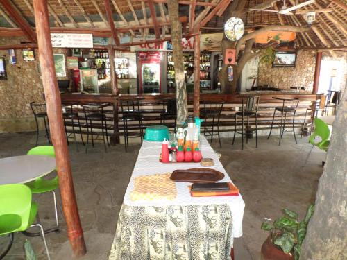 a long table in a restaurant with chairs and tables at Pinebreeze Holiday Resort in Nyali