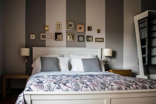 a bedroom with a large bed and some pictures on the wall at B&B La Cuntana in Potenza