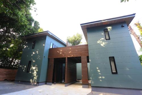 a blue house with a brown roof at Tabinoteitaku Okinawa Bise HOMANN CONCEPT in Motobu