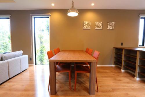 a dining room with a wooden table and chairs at Tabinoteitaku Okinawa Bise HOMANN CONCEPT in Motobu