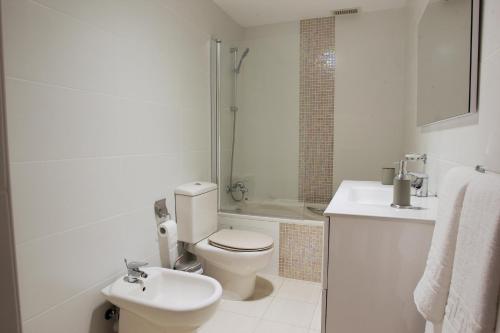 a white bathroom with a toilet and a sink at Chalet Costa Adeje in Adeje
