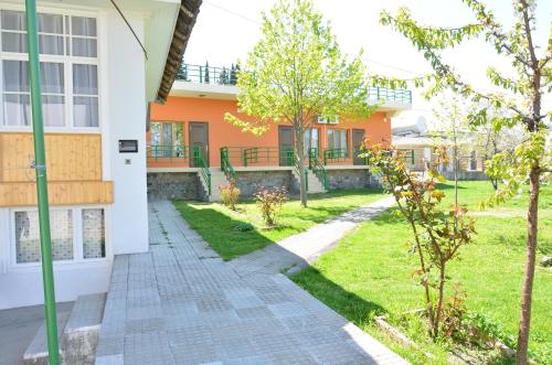 an orange and white house with a walkway at Sheki Panorama Guest House in Sheki