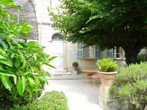 a courtyard of a house with plants and a table at Les Passiflores in Grasse