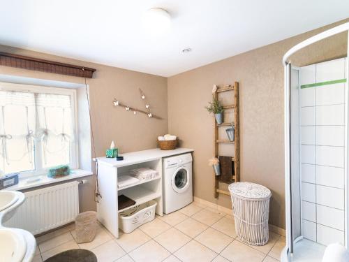 a bathroom with a washer and dryer in it at Au pré des Poulains in Ostheim