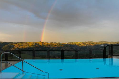 un arc-en-ciel au-dessus d'une piscine avec un arc-en-ciel dans l'établissement Antica Corte Casa Marini, à Polinago