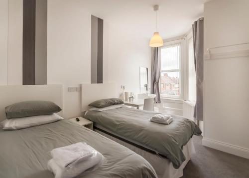 a bedroom with two beds and a window at Kingswood Guest House in Stockton-on-Tees