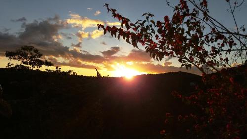 a sunset with the sun setting on a hill at Refúgio do Azzi in Monte Verde