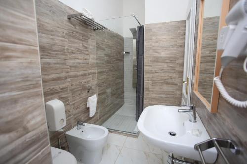 a bathroom with a sink and a toilet and a shower at Hotel Vergilius Billia in Naples