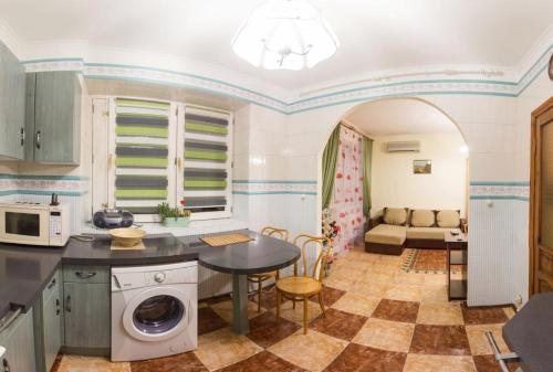 a kitchen with a table with a washing machine at Kyiv apartment on Pavlovskaya street in Kyiv