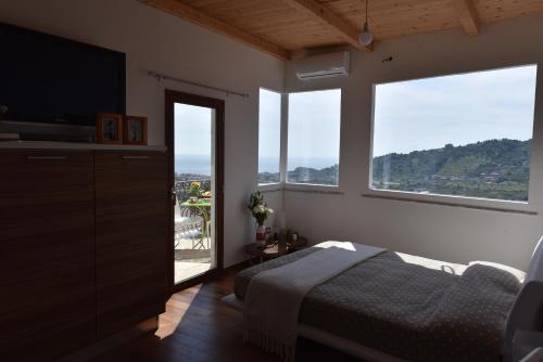 a bedroom with a bed and a large window at B&B Villa Grazia in Pagliara