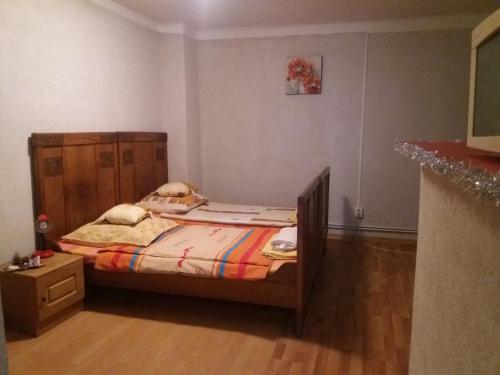 a small bedroom with a bed with a wooden headboard at Casa Rodisa in Turda
