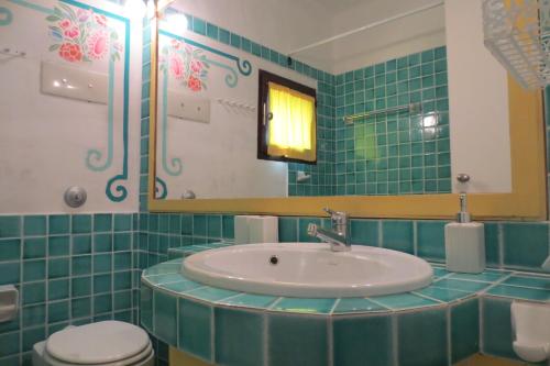 a bathroom with a sink and a toilet and a mirror at Residence I Cormorani Bis in Baja Sardinia