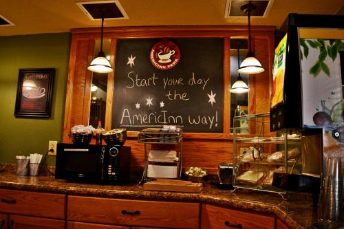 a counter with a sign that says start your day the american way at AmericInn by Wyndham Calumet in Calumet