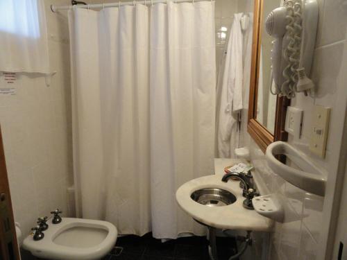 a bathroom with a white shower curtain and a sink at The Paradise in Puerto Pirámides