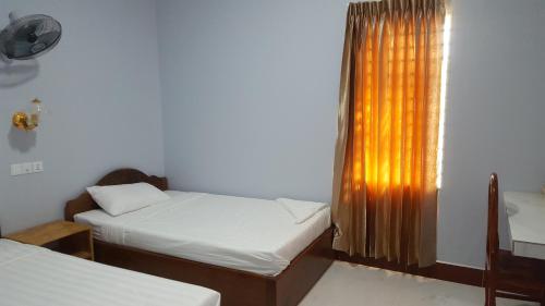 a bedroom with two twin beds and a window at KampongBay Makeng II Guesthouse in Kampot